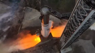 SpaceX Starship test firing with flames and steam visible.