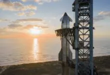 SpaceX Starship on launchpad at sunrise, ocean backdrop.