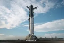 SpaceX Starship rocket on launchpad against a blue sky with scattered clouds.