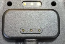 Close-up of a gray device with charging pins.