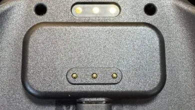 Close-up of a gray device with charging pins.