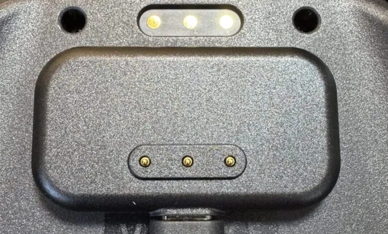 Close-up of a gray device with charging pins.