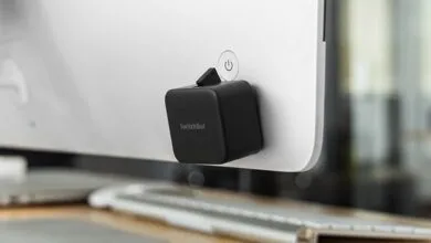 SwitchBot attached to a monitor power button for smart home automation.