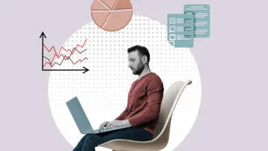 Man working on laptop with charts and documents floating around him.