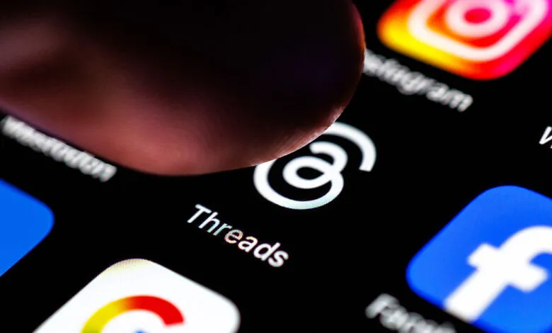 Finger about to tap Threads app icon on a smartphone screen.