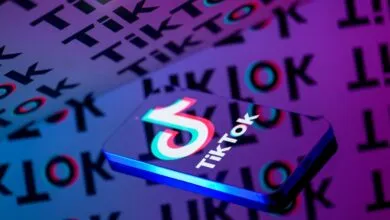 TikTok logo on a phone against a background of TikTok text.