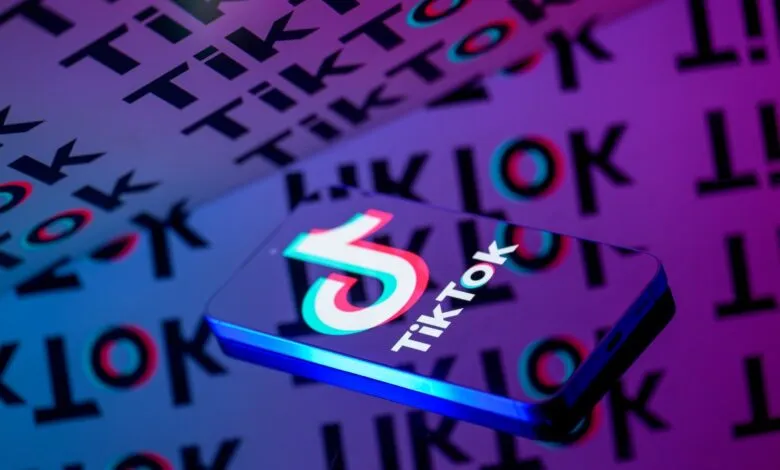 TikTok logo on a phone against a background of TikTok text.