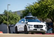 White Waymo Jaguar I-Pace self-driving car on a sunny street.