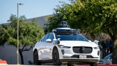 White Waymo Jaguar I-Pace self-driving car on a sunny street.