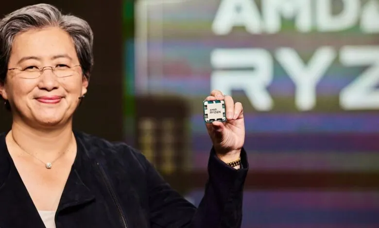 Lisa Su holds up an AMD Ryzen processor, smiling confidently.