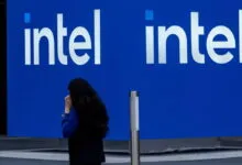 Intel logo on a blue wall with a person walking by.