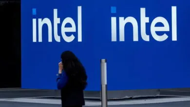 Intel logo on a blue wall with a person walking by.