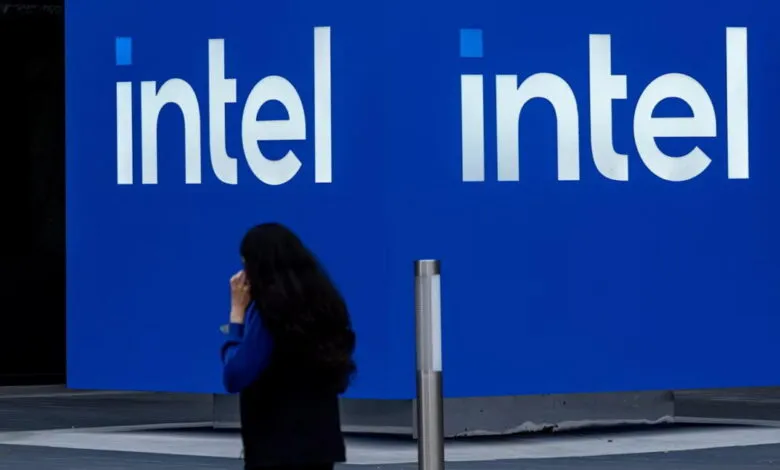 Intel logo on a blue wall with a person walking by.