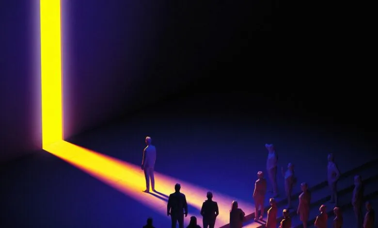 People stand in the dark, watching a bright yellow light stream through a vertical crack in a dark wall.