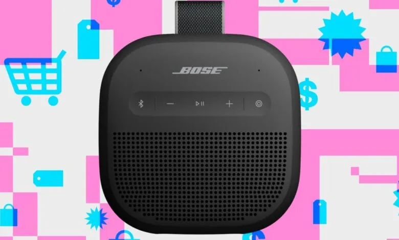 Black Bose SoundLink Micro speaker against a pink, blue, and white shopping-themed background.