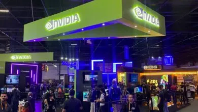 Large NVIDIA booth glowing in vibrant green and blue lights at a bustling gaming convention event.