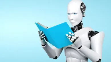 A white humanoid robot with glowing blue eyes holds and reads an open bright blue book against a light blue background.