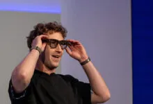 Mark Zuckerberg adjusts Meta Ray-Ban Display AI glasses on stage during Meta Connect