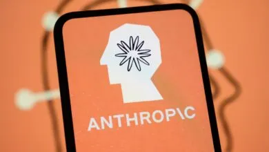Smartphone displaying the Anthropic logo with a stylized head and floral brain on an orange background.