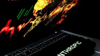 Laptop displaying a colorful world map graphic and the Anthropic logo on screen and phone.