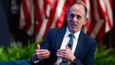 Venture capitalist Keith Rabois speaks on stage against an American flag backdrop