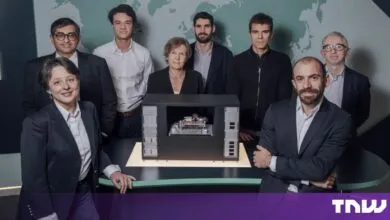 Group portrait of the Pasqal leadership team posing around a quantum computer model.
