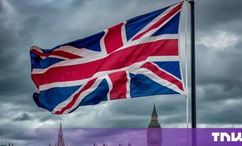Union Jack flag waving proudly against a dramatic, stormy sky in London.