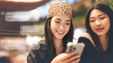 Two young women smiling while interacting with a smartphone and floating AI chat interfaces.