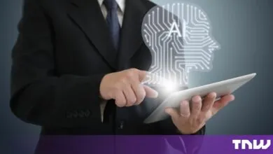 A businessman in a suit uses a tablet with a glowing AI circuit board head graphic above it.