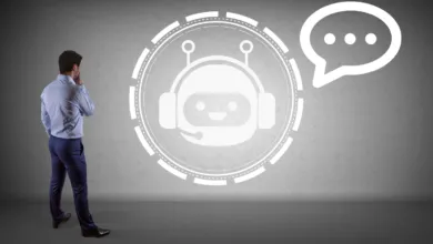 A man in a shirt and trousers looks at a glowing white AI chatbot and speech bubble projection on a wall.