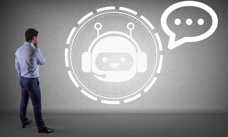 A man in a shirt and trousers looks at a glowing white AI chatbot and speech bubble projection on a wall.