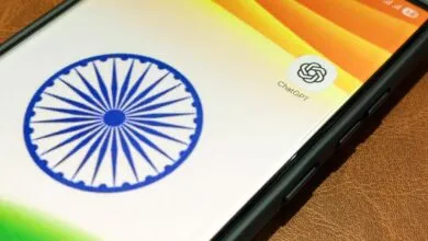 Smartphone displaying the Indian flag colors and ChatGPT app icon on a brown leather surface