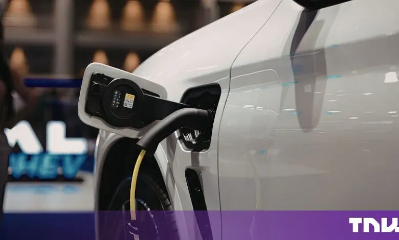 Close-up of a white electric vehicle plugged into a charging station