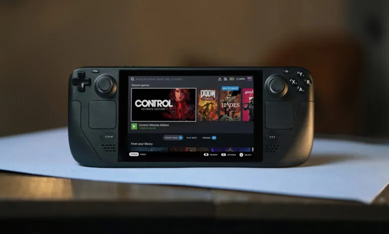 Black Steam Deck handheld gaming console displaying the user interface on a light blue surface