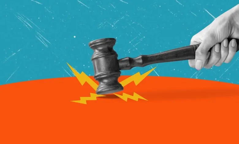 A hand brings down a wooden judge's gavel onto an orange surface, creating yellow lightning bolt graphics.