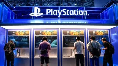Gamers testing PlayStation consoles at brightly lit exhibition booths
