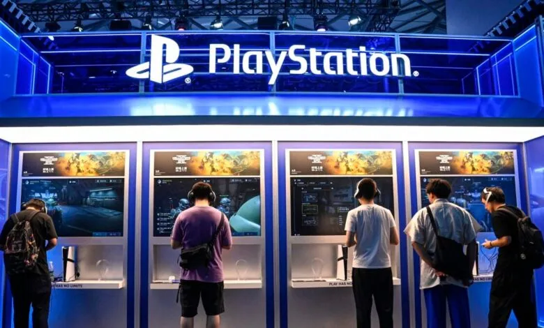 Gamers testing PlayStation consoles at brightly lit exhibition booths