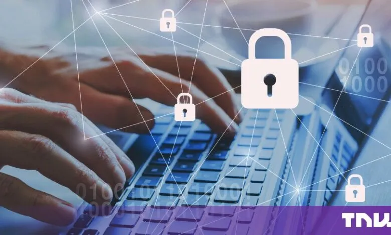 Hands typing on a laptop with glowing blue digital security padlocks and binary code overlays.