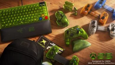 Collection of Xbox 25th Anniversary gaming gear including keyboard, mouse, and controllers on wooden table