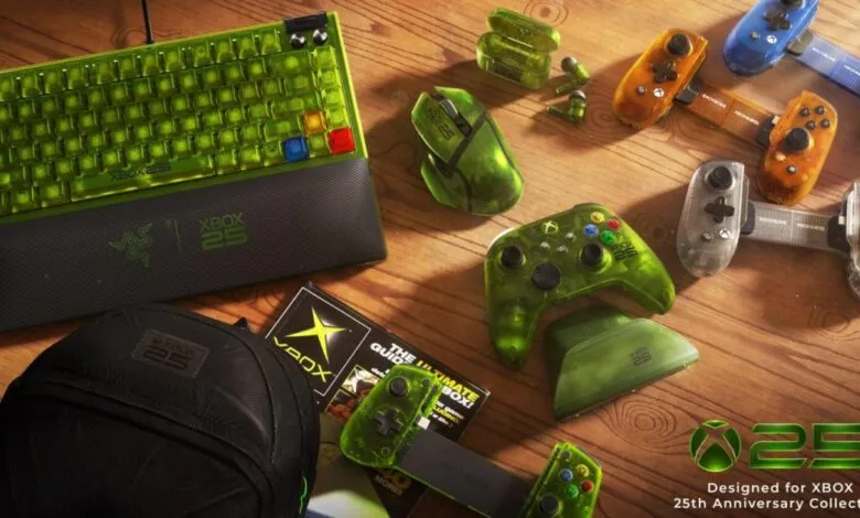 Collection of Xbox 25th Anniversary gaming gear including keyboard, mouse, and controllers on wooden table