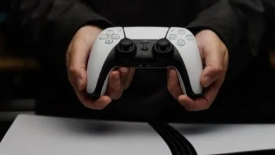 Close-up of hands holding a white and black PlayStation 5 DualSense controller.