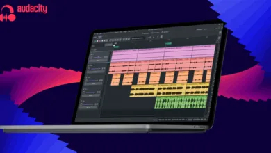 Laptop displaying Audacity audio editing software against a blue and pink abstract background