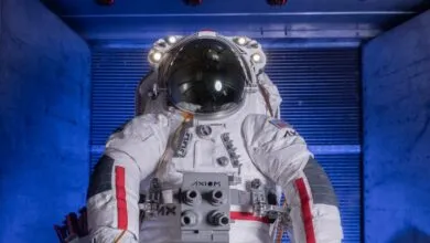An Axiom Space spacesuit undergoing thermal vacuum testing inside a specialized facility.