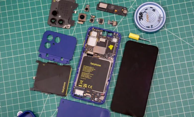 Disassembled modular Fairphone with internal components spread across a green cutting mat.