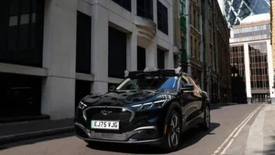 Black autonomous Ford Mustang Mach-E parked on a narrow London street with sensors on the roof.