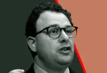 Portrait of Dario Amodei, CEO of Anthropic, wearing glasses and speaking.