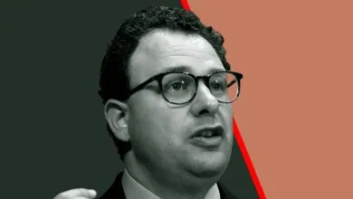 Portrait of Dario Amodei, CEO of Anthropic, wearing glasses and speaking.