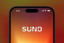 Close-up of a smartphone display showing the Suno logo on a warm gradient background.