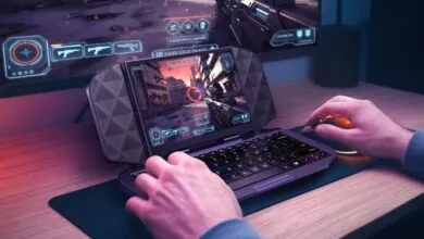 Gamer plays an action game on a unique portable gaming device with an integrated keyboard.