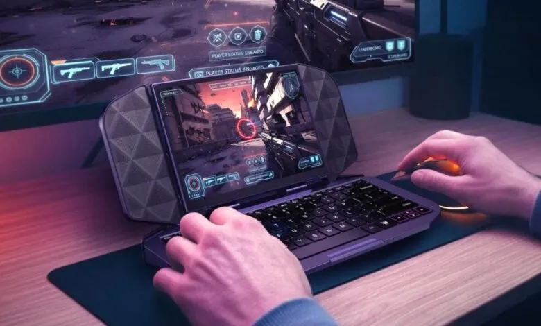 Gamer plays an action game on a unique portable gaming device with an integrated keyboard.